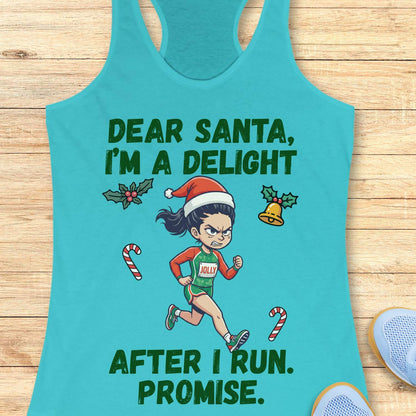 blue racerback tank top displayed on a light wooden surface, featuring a festive running-themed graphic. The design shows a cartoon runner wearing a Santa hat, green running outfit with the word “JOLLY” on the chest, and running shoes. Holiday elements including holly leaves, a Christmas bell, and candy canes surround the runner. Bold green text above and below the illustration reads: “DEAR SANTA, I’M A DELIGHT” and “AFTER I RUN. PROMISE.” Partial blue athletic shoes are visible in the lower corners