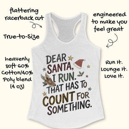 white racerback tank top displayed on a light wooden surface, featuring a festive running-themed typographic design. The graphic includes the humorous text: “DEAR SANTA, I RUN. THAT HAS TO COUNT FOR SOMETHING.” Decorative holiday elements surround the text, including a red Santa hat, a winged running shoe, holly sprigs with berries, and colorful stars. The word “COUNT” is highlighted in yellow, while the remaining text appears in black. Partial blue athletic shoes are visible in the lower corners, rei