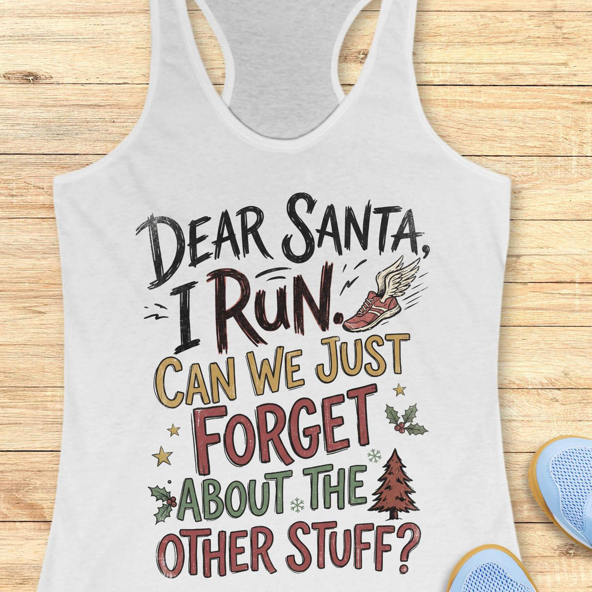 White racerback tank top displayed on a light wooden surface, featuring a festive running-themed typography design. The graphic includes the humorous text: “DEAR SANTA, I RUN. CAN WE JUST FORGET ABOUT THE OTHER STUFF?” Decorative holiday accents surround the text, including a winged running shoe, holly sprigs with red berries, gold stars, snowflakes, and a Christmas tree. The design uses black, red, green, and gold lettering for a playful holiday look. Partial blue athletic shoes are visible in the lower co