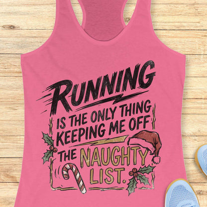 pink racerback tank top displayed on a light wooden surface, featuring a festive running-themed typography design. The graphic displays the humorous text: “RUNNING IS THE ONLY THING KEEPING ME OFF THE NAUGHTY LIST.” Holiday decorations include a red Santa hat, holly sprigs with red berries, a striped candy cane, and accent graphics surrounding the text. The words “NAUGHTY LIST” are highlighted in gold, while the remaining text appears in black. Partial blue athletic shoes are visible in the lower corn