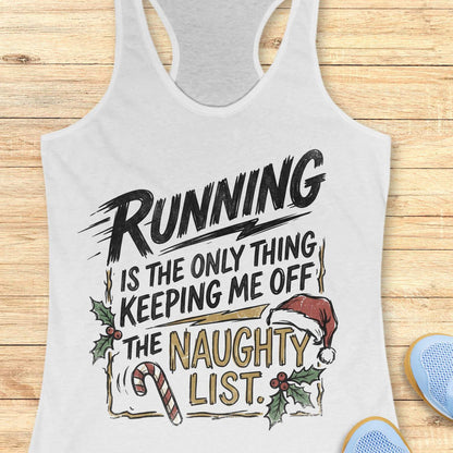 white racerback tank top displayed on a light wooden surface, featuring a festive running-themed typography design. The graphic displays the humorous text: “RUNNING IS THE ONLY THING KEEPING ME OFF THE NAUGHTY LIST.” Holiday decorations include a red Santa hat, holly sprigs with red berries, a striped candy cane, and accent graphics surrounding the text. The words “NAUGHTY LIST” are highlighted in gold, while the remaining text appears in black. Partial blue athletic shoes are visible in the lower corn