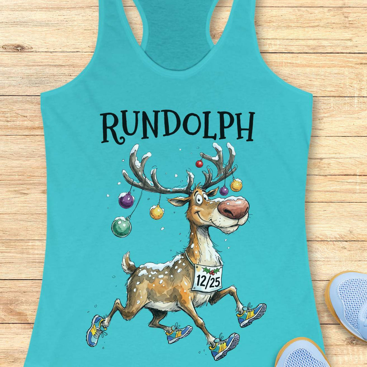 blue racerback tank top featuring the word “RUNDOLPH” above a playful cartoon reindeer running in colorful athletic shoes. The reindeer has snow-dusted antlers decorated with hanging Christmas ornaments and wears a race bib displaying “12/25.” Snowflakes are scattered throughout the design, adding a festive winter feel. The humorous artwork combines holiday cheer and running culture, making it perfect for runners who love Christmas-themed race apparel.