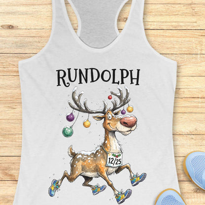 white racerback tank top featuring the word “RUNDOLPH” above a playful cartoon reindeer running in colorful athletic shoes. The reindeer has snow-dusted antlers decorated with hanging Christmas ornaments and wears a race bib displaying “12/25.” Snowflakes are scattered throughout the design, adding a festive winter feel. The humorous artwork combines holiday cheer and running culture, making it perfect for runners who love Christmas-themed race apparel.