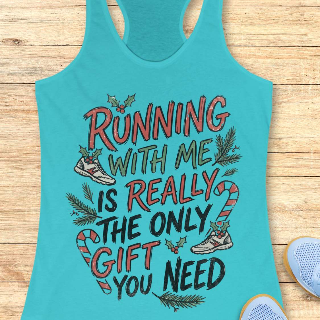 Tahiti blue racerback tank top featuring the festive running-themed phrase “RUNNING WITH ME IS REALLY THE ONLY GIFT YOU NEED” in large red, green, and black hand-lettered text. The design is decorated with candy canes, holly leaves and berries, evergreen branches, and running shoes accented with holiday greenery. The playful Christmas artwork combines holiday cheer with a runner’s sense of humor. The tank top is displayed on a light wood background with partial blue running shoes visible in the corners.