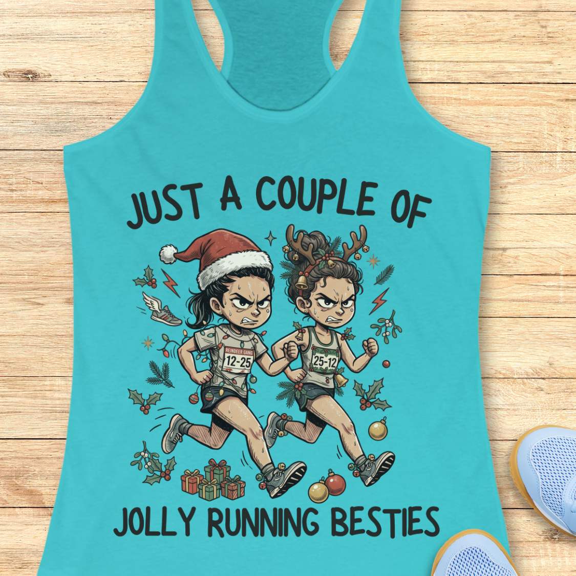 blue racerback running tank top displayed on a wooden background featuring a festive illustration of two runners in holiday outfits. One runner wears a Santa hat and the other wears reindeer antlers adorned with Christmas decorations. The runners are dressed in race gear, surrounded by holly, ornaments, presents, and holiday accents. The design includes the text: “JUST A COUPLE OF JOLLY RUNNING BESTIES.” Blue running shoes are partially visible at the bottom corners of the image.