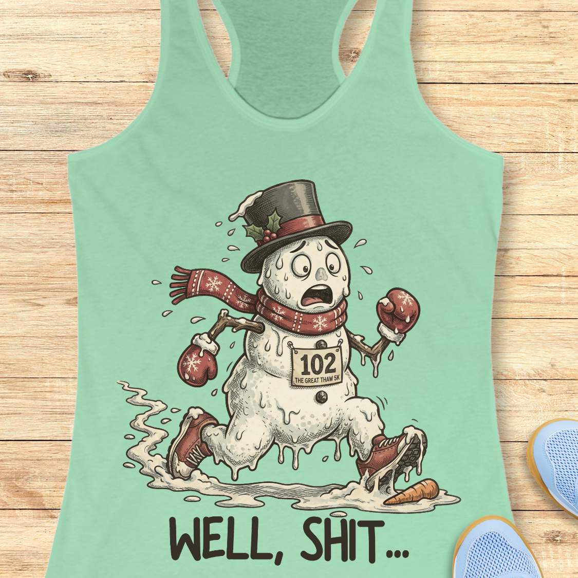 Funny Christmas running tank top featuring a melting snowman runner wearing red running shoes, boxing gloves, a scarf, and a top hat. The snowman has a race bib labeled "102 The Great Thaw 5K" and is shown melting while running through puddles, with a carrot nose fallen on the ground ahead. Large text below reads, "WELL, SHIT..." The design is printed on a heather gray racerback tank top and combines holiday humor with runner frustration.