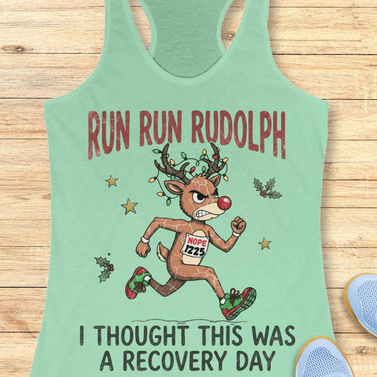 Funny Christmas runner tank top featuring Rudolph the Red-Nosed Reindeer dressed as a runner, sprinting in red and green running shoes with a race bib that reads "NOPE 1225." Rudolph's antlers are wrapped in colorful Christmas lights, and festive holly leaves and stars surround the character. Large distressed text reads, "RUN RUN RUDOLPH" above the illustration and "I THOUGHT THIS WAS A RECOVERY DAY" below. The design is printed on a mint green racerback tank top and combines holiday humor with a relatable 
