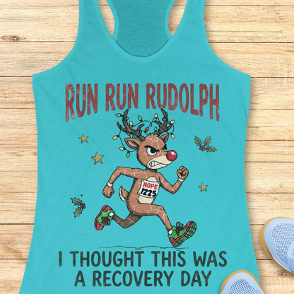 Funny Christmas runner tank top featuring Rudolph the Red-Nosed Reindeer dressed as a runner, sprinting in red and green running shoes with a race bib that reads "NOPE 1225." Rudolph's antlers are wrapped in colorful Christmas lights, and festive holly leaves and stars surround the character. Large distressed text reads, "RUN RUN RUDOLPH" above the illustration and "I THOUGHT THIS WAS A RECOVERY DAY" below. The design is printed on a mint green racerback tank top and combines holiday humor with a relatable 