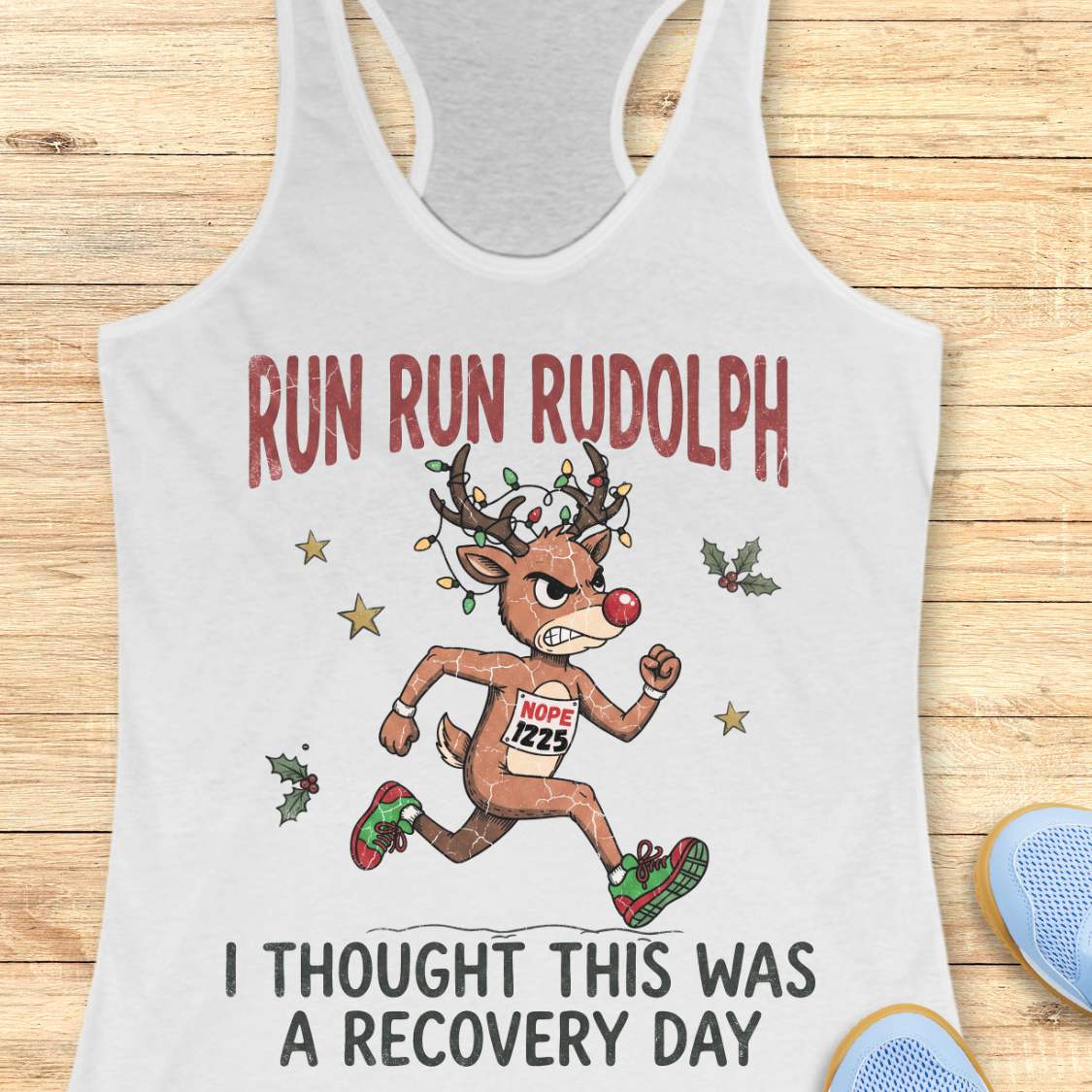 Funny Christmas runner tank top featuring Rudolph the Red-Nosed Reindeer dressed as a runner, sprinting in red and green running shoes with a race bib that reads "NOPE 1225." Rudolph's antlers are wrapped in colorful Christmas lights, and festive holly leaves and stars surround the character. Large distressed text reads, "RUN RUN RUDOLPH" above the illustration and "I THOUGHT THIS WAS A RECOVERY DAY" below. The design is printed on a mint green racerback tank top and combines holiday humor with a relatable 