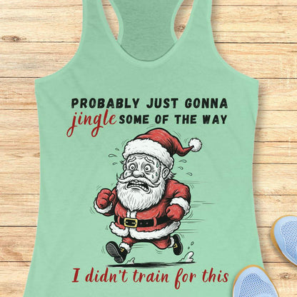 A mint green racerback tank top laid flat on a light wood background, featuring a humorous graphic of a running Santa Claus with the text 'PROBABLY JUST GONNA jingle SOME OF THE WAY I didn't train for this'.