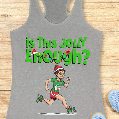 Graphic design on a grey tank top depicting a determined cartoon woman in a Santa hat running a Christmas race, wearing a green shirt with a GREEN XMAS bib, red shorts, and green shoes, below the text Is This Jolly Enough adorned with festive lights and a tiny Santa hat