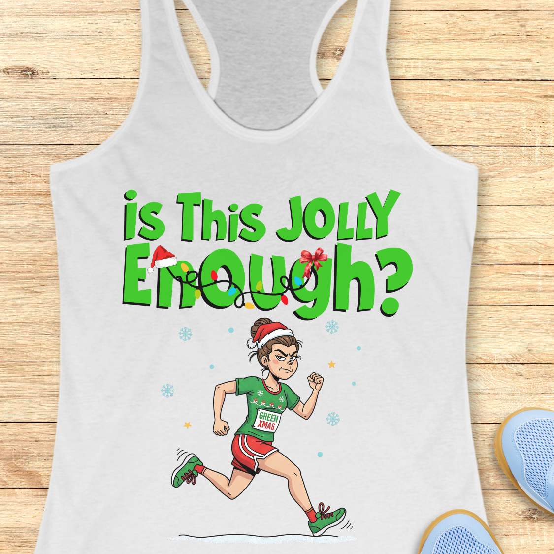 A white racerback tank top laid flat on a light wood background, featuring a green graphic that reads 'is This JOLLY Enough?' with a cartoon female runner wearing a Santa hat and green race shoes.