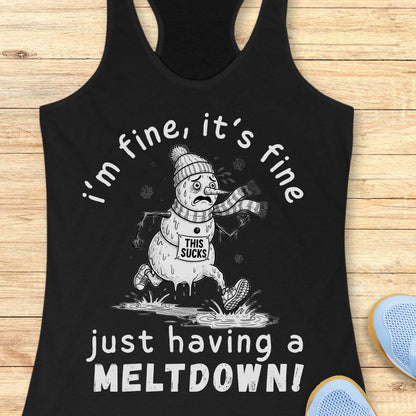 A black racerback tank top with a white graphic of a sad snowman and the text 'i'm fine, it's fine just having a MELTDOWN!' displayed on a light wood background with blue shoes partially visible.