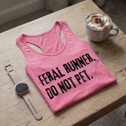 a video with a pink tank top with the slogan "feral runner. Do not pet.", on a coffee table, with a smart watch and a hot chocolate mug. 