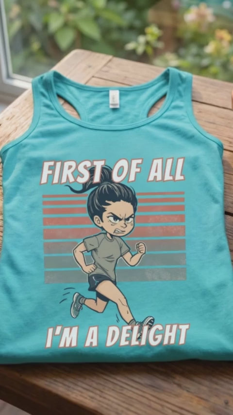 A video of a women runner turquoise tank top laid flat on a wooden table, featuring a cartoon running man graphic with the text 'FIRST OF ALL I'M A DELIGHT'. A ceramic mug of coffee and a small potted succulent sit beside it, with a window and garden visible in the background.